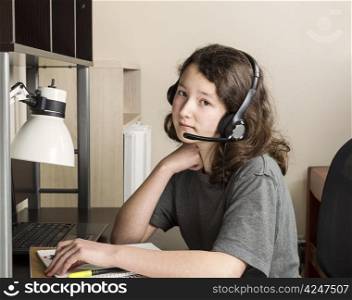 Young girl preparing to do homework with headset on while sitting at her desk