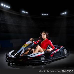 Young girl racer with kart at stadium
