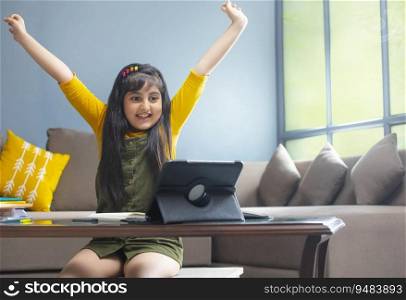 Young girl raising her hands cheerfully after her online class