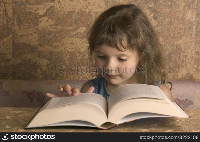 Young Girl Reading From A Big Book