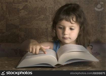 Young Girl Reading From A Big Book