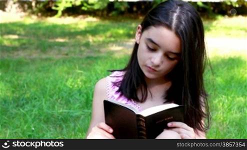 Young Girl reading Holy Bible. Spiritual momment for a teenage girl.