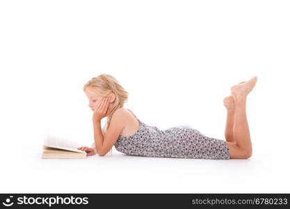 young girl reads a book lying down on the floor of studio against white background