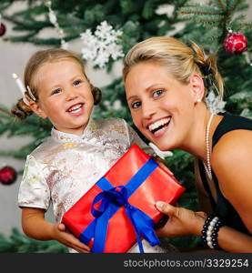 Young girl receives a gift by her mother