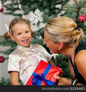 Young girl receives a gift by her mother