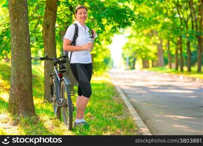young girl resting in a park with a bicycle