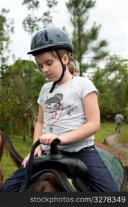 Young girl riding a horse at Mountain Pine Ridge Reserve in Belize