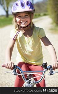Young Girl Riding Bike Along Country Track