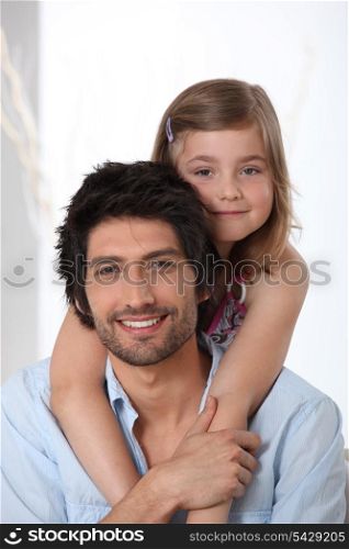 Young girl riding piggy-back on her father&rsquo;s back