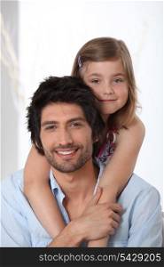 Young girl riding piggy-back on her father&rsquo;s back
