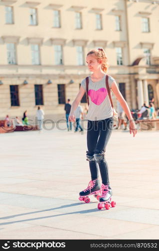 Young girl roller skating in a town spending time actively outdoors on summer day