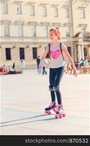 Young girl roller skating in a town spending time actively outdoors on summer day