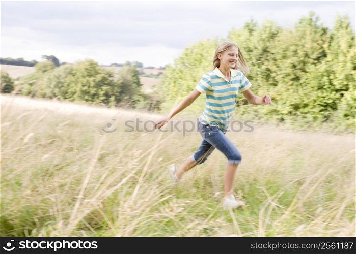 Young girl running in a field smiling