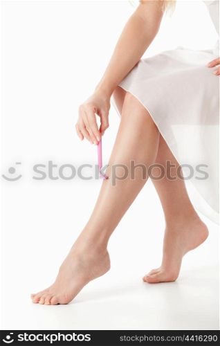 Young girl shaves his leg on a white background