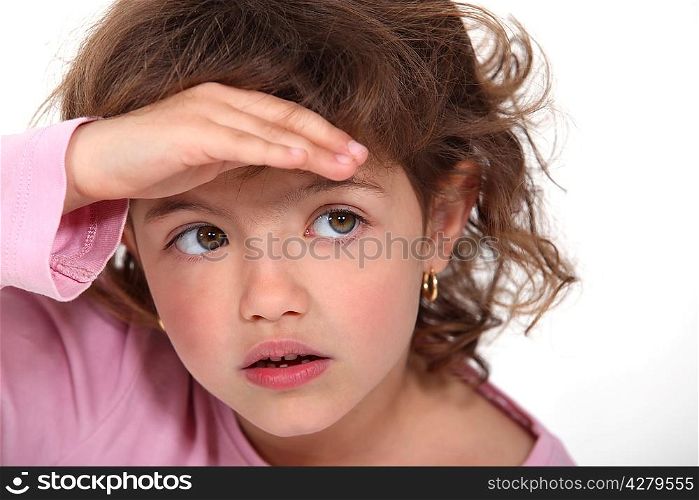Young girl shielding her eyes from the sunlight