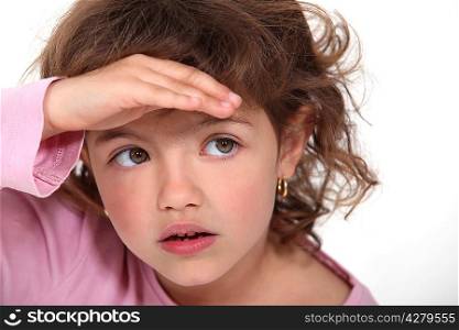 Young girl shielding her eyes from the sunlight