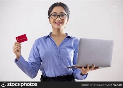Young girl shopping online through laptop using credit card