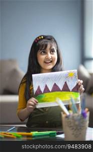 Young girl showing artwork she made at home 