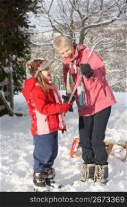Young Girl Showing Grandmother Icicle In Snowy Landscape