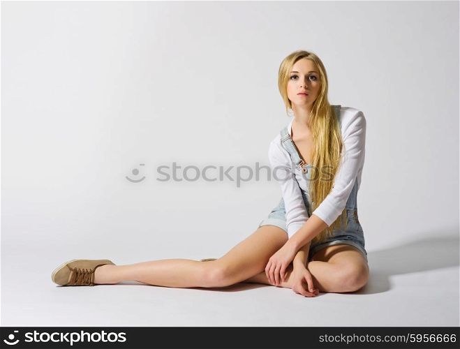 Young girl sit on the floor on grey background