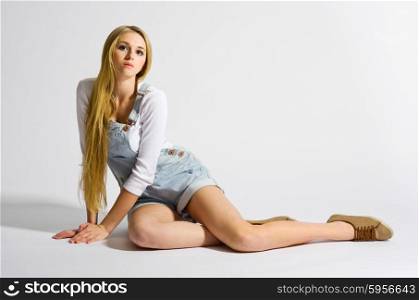 Young girl sit on the floor on light grey background
