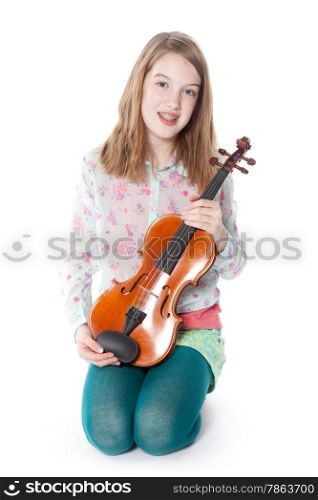 young girl sits in studio against white background and holds violin