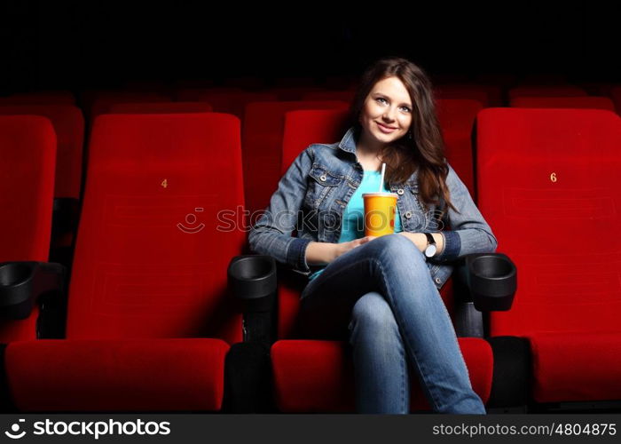 Young girl sitting in cinema and watching movie