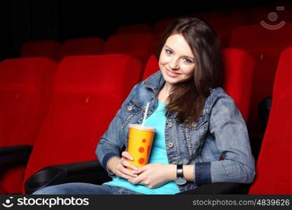 Young girl sitting in cinema and watching movie