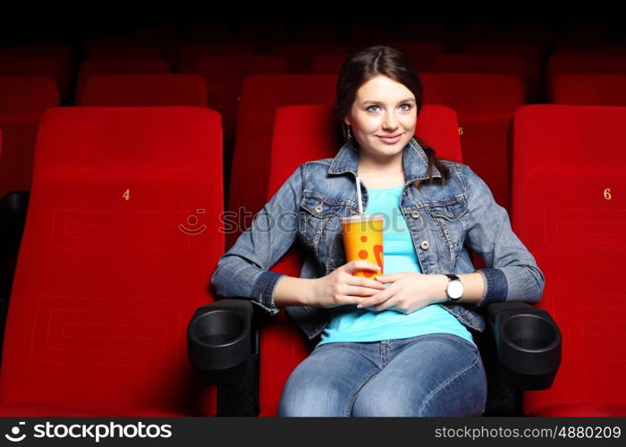 Young girl sitting in cinema and watching movie