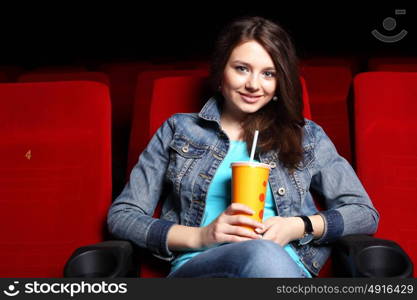 Young girl sitting in cinema and watching movie