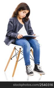 Young girl sitting on a chair and using a tablet