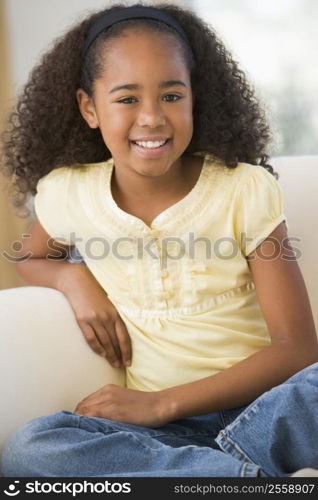 Young Girl Sitting On A Sofa At Home