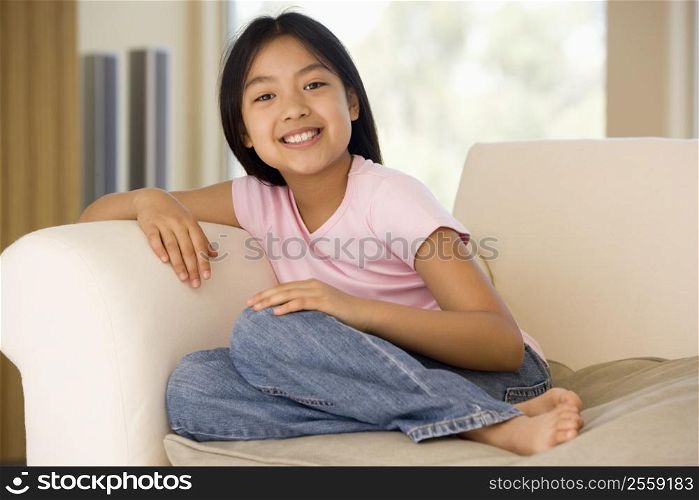 Young Girl Sitting On A Sofa At Home