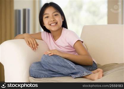 Young Girl Sitting On A Sofa At Home
