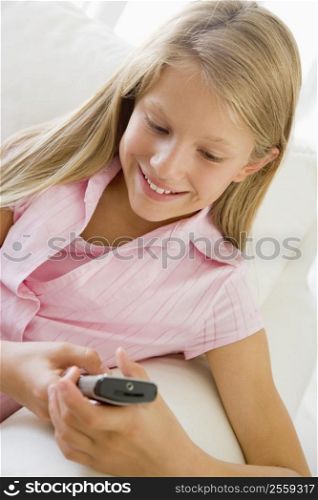 Young Girl Sitting On A Sofa Texting On A Cellphone
