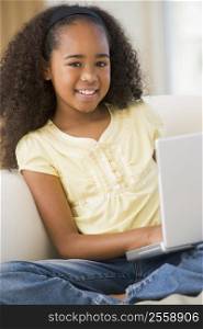 Young Girl Sitting On A Sofa, Using A Laptop