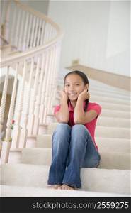 Young Girl Sitting On A Stairwell At Home