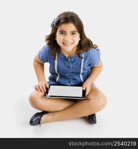 Young girl sitting on floor and using a tablet