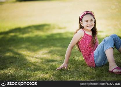 Young girl sitting on grass laughing