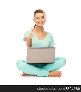 young girl sitting on the floor with laptop showing thumbs up