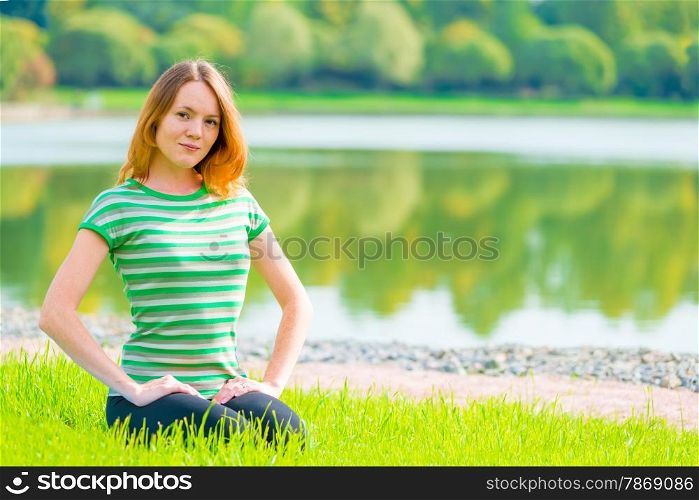 young girl sitting on the grass and beautiful smiles