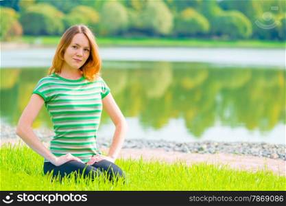 young girl sitting on the grass and beautiful smiles