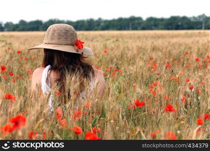 young girl sitting on the wheat field