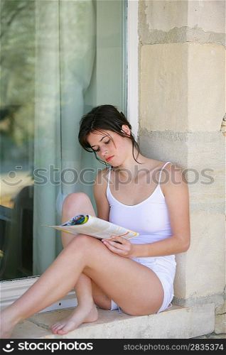 Young girl sitting on window sill