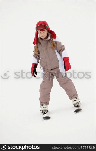 Young Girl Skiing Down Slope On Holiday In Mountains