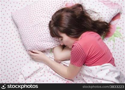 Young girl sleeping in bed covered with a blanket