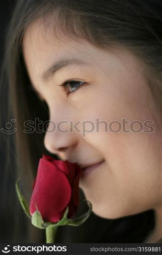 Young girl smelling a flower
