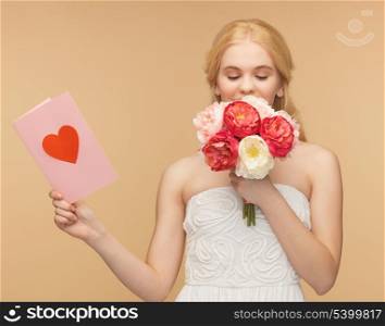 young girl smelling flowers and holding postcard