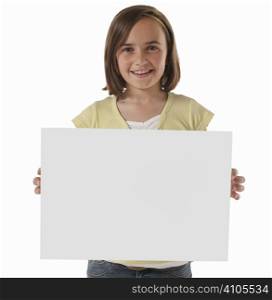young girl smiling at camera holding a blank panel in front of her body on white background