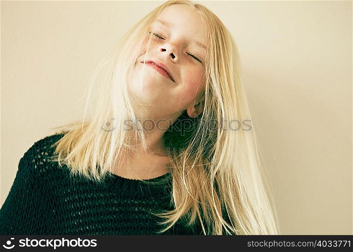 Young girl smiling with eyes closed, close up